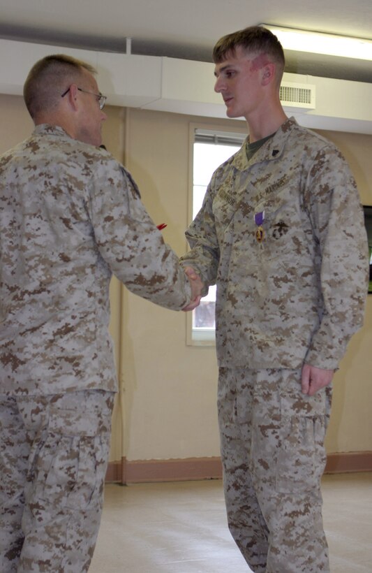 050228-M-2607O-004 MARINE CORPS BASE CAMP LEJEUNE, N.C. (February 28, 2005) – Corporal Benjamyn R. O’Connor, a field artillery fire control man with 5th Battalion, 10th Marine Regiment, shakes hands with Col. Thomas L. Cariker, regimental commander, after receiving his Purple Heart for being wounded in Iraq during Operation Iraqi Freedom.  He plans to go back to school when he gets out of the corps in a year and finish what he started.