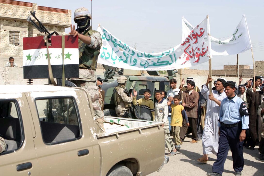 CAMP FALLUJAH, IRAQ – Iraqis from the surrounding area of Nasser Wa Salaam gathered together for a peace rally after two Iraqi National Guardsman died a few days earlier from insurgent attacks.  Walking up to the local police station chanting, they showed their support for a peaceful Iraq and support for Coalition Forces.  Company K, 3rd Battalion, 8th Marine Regiment, Regimental Combat Team 8, provided security around the police station and surrounding areas as the rally moved throughout the area.  Official U.S. Marine Corps Photo by Lance Cpl. Athanasios Genos.