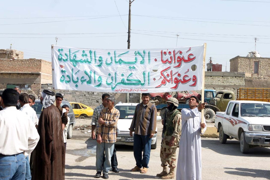 CAMP FALLUJAH, IRAQ – Iraqis from the surrounding area of Nasser Wa Salaam gathered together for a peace rally after two Iraqi National Guardsman died a few days earlier from insurgent attacks.  Walking up to the local police station chanting, they showed their support for a peaceful Iraq and support for Coalition Forces.  Company K, 3rd Battalion, 8th Marine Regiment, Regimental Combat Team 8, provided security around the police station and surrounding areas as the rally moved throughout the area.  Official U.S. Marine Corps Photo by Lance Cpl. Athanasios Genos.