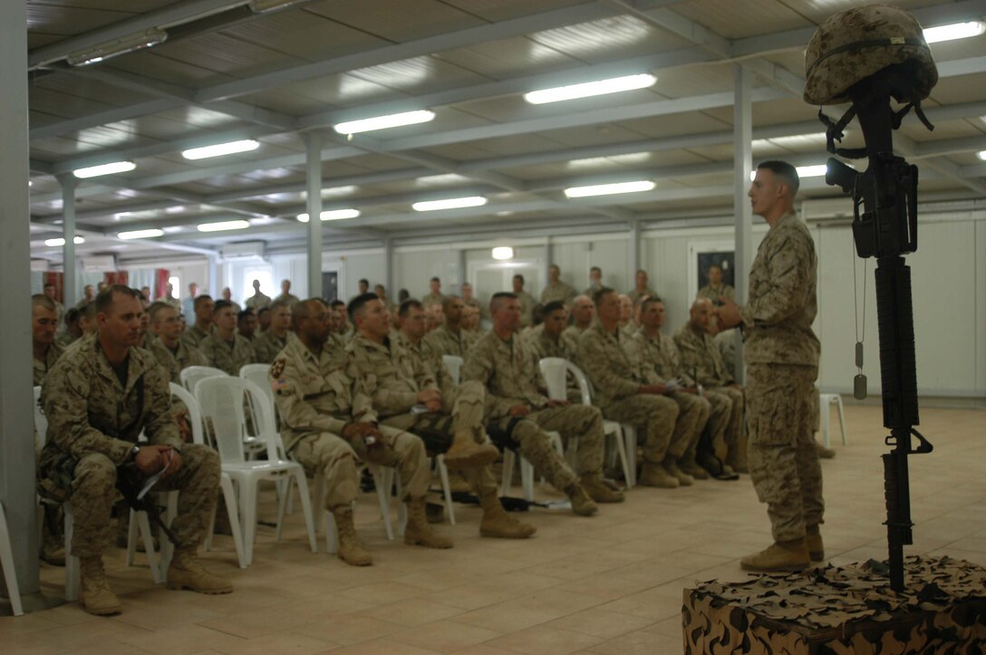 CAMP RAMADI, Ar Ramadi, Iraq (April 19, 2005) -First Lt. Stephen G. Lewis, executive officer, Company B, 1st Battalion, 5th Marine Regiment, delivers a tribute to the late commanding officer of Company B, Capt. Jamie C. Edge, during a memorial ceremony in the dining facility here. Edge, a 32-year-old Marine leader from Virginia Beach, Va., was killed by enemy fire while conducting a combat patrol with his men. He's best remembered for being hardworking, dedicated, professional and caring. Edge is survived by his wife, Krissy, and two daughters, Helena and Rachel. Photo by Cpl. Tom Sloan