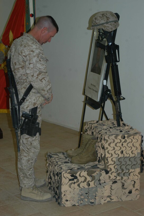 CAMP RAMADI, Ar Ramadi, Iraq (April 19, 2005) - Lieutenant Col. Eric M. Smith, commanding officer, 1st Battalion, 5th Marine Regiment, stands in front of a warriors memorial and pays his respects to Capt. Jamie C. Edge. A memorial ceremony for the late commanding officer of the infantry battalion's Company B was held in the dining facility here. Edge, a 32-year-old Marine leader from Virginia Beach, Va., was killed by enemy fire while conducting a combat patrol with his men. He's best remembered for being hardworking, dedicated, professional and caring. Edge is survived by his wife, Krissy, and two daughters, Helena and Rachel. Photo by Cpl. Tom Sloan