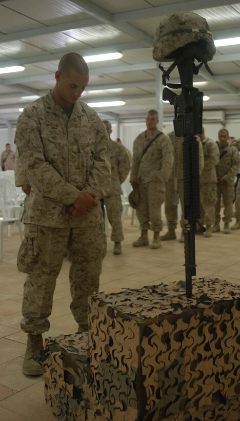 CAMP RAMADI, Ar Ramadi, Iraq (April 19, 2005) -Corporal Donald W. Ball, squad leader, 3rd Squad, Weapons Platoon, Company B, 1st Battalion, 5th Marine Regiment, stands in front of a warriors memorial and pays his respects to Capt. Jamie C. Edge. A memorial ceremony for the late commanding officer of the infantry battalion's Company B was held in the dining facility here. Edge, a 32-year-old Marine leader from Virginia Beach, Va., was killed by enemy fire while conducting a combat patrol with his men. He's best remembered for being hardworking, dedicated, professional and caring. Edge is survived by his wife, Krissy, and two daughters, Helena and Rachel. Photo by Cpl. Tom Sloan