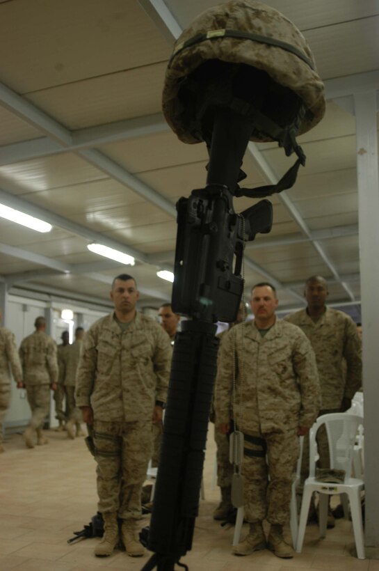 CAMP RAMADI, Ar Ramadi, Iraq (April 19, 2005) -Marines with 1st Battalion, 5th Marine Regiment, stand at attention in front of a warriors memorial and pay their respects to Capt. Jamie C. Edge. A memorial ceremony for the late commanding officer of the infantry battalion's Company B was held in the dining facility here. Edge, a 32-year-old Marine leader from Virginia Beach, Va., was killed by enemy fire while conducting a combat patrol with his men. He's best remembered for being hardworking, dedicated, professional and caring. Edge is survived by his wife, Krissy, and two daughters, Helena and Rachel. Photo by Cpl. Tom Sloan