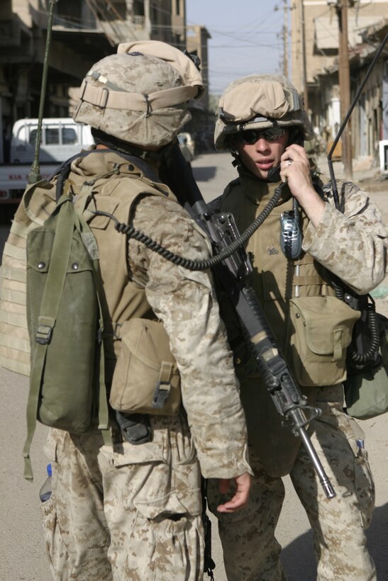 FALLUJAH, Iraq - Cpl. Timothy Patterson, 2nd Squad's leader, 3rd Platoon, Company C, 1st Battalion, 6th Marine Regiment, talks on the radio as he patrols the city streets alongside his fellow Marines May 28.  The unit is currently conducting security and stability operations alongside Iraqi Security Forces here.