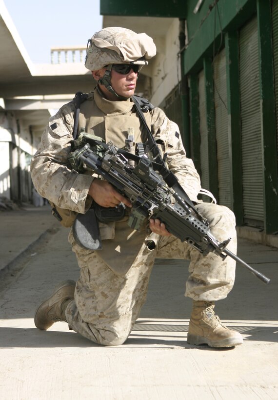 FALLUJAH, Iraq - A Marine with 2nd Squad, 3rd Platoon, Company C, 1st Battalion, 6th Marine Regiment kneels down as he provides security for his patrol passing through the streets here May 28.  The unit is currently conducting security and stability operations alongside Iraqi Security Forces here.