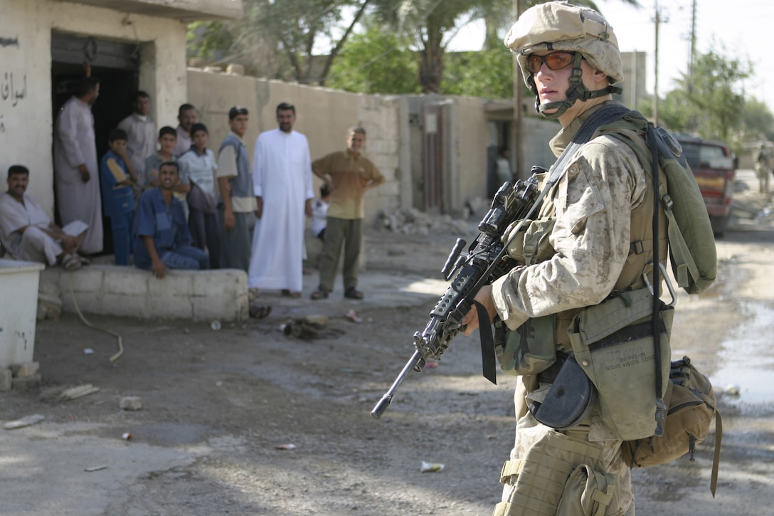 FALLUJAH, Iraq - Lance Cpl. William Holls, an infantryman with 2nd Squad, 3rd Platoon, Company C, 1st Battalion, 6th Marine Regiment, observes his surroundings as his unit patrols the city streets here May 28.  The unit is currently conducting security and stability operations alongside Iraqi Security Forces here.