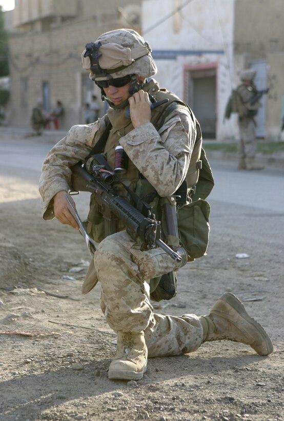 FALLUJAH, Iraq - Lance Cpl. Richard Shedd, an infantryman with 2nd Squad, 3rd Platoon, Company C, 1st Battalion, 6th Marine Regiment, kneels down and communicates with fellow Marines here May 28 as he checks his patrol's position on a map.  The unit is currently conducting security and stability operations alongside Iraqi Security Forces here.