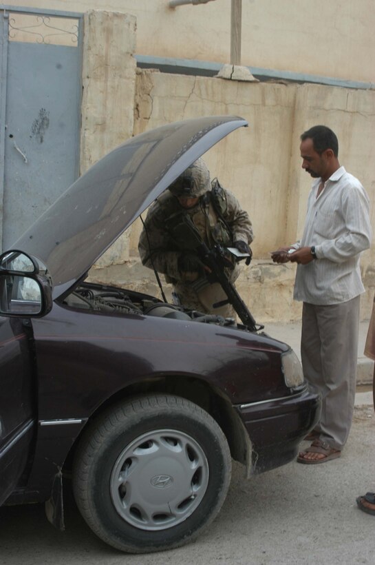 AR RAMADI Iraq (June 29, 2005) -Sergeant Joe A. Salinas, squad leader for 3rd Squad, 4th Platoon, Company B, 1st Battalion, 5th Marine Regiment, searches an Iraqi man's car during a mission in the city here June 28. The 35-year-old from San Antonio, Texas and his fellow Marines conducted a patrol through a portion of their company's area of operations to locate enemy sniper positions. Company B's observation post has been taking sporadic sniper fire from the area around it. Photo by: Cpl. Tom Sloan