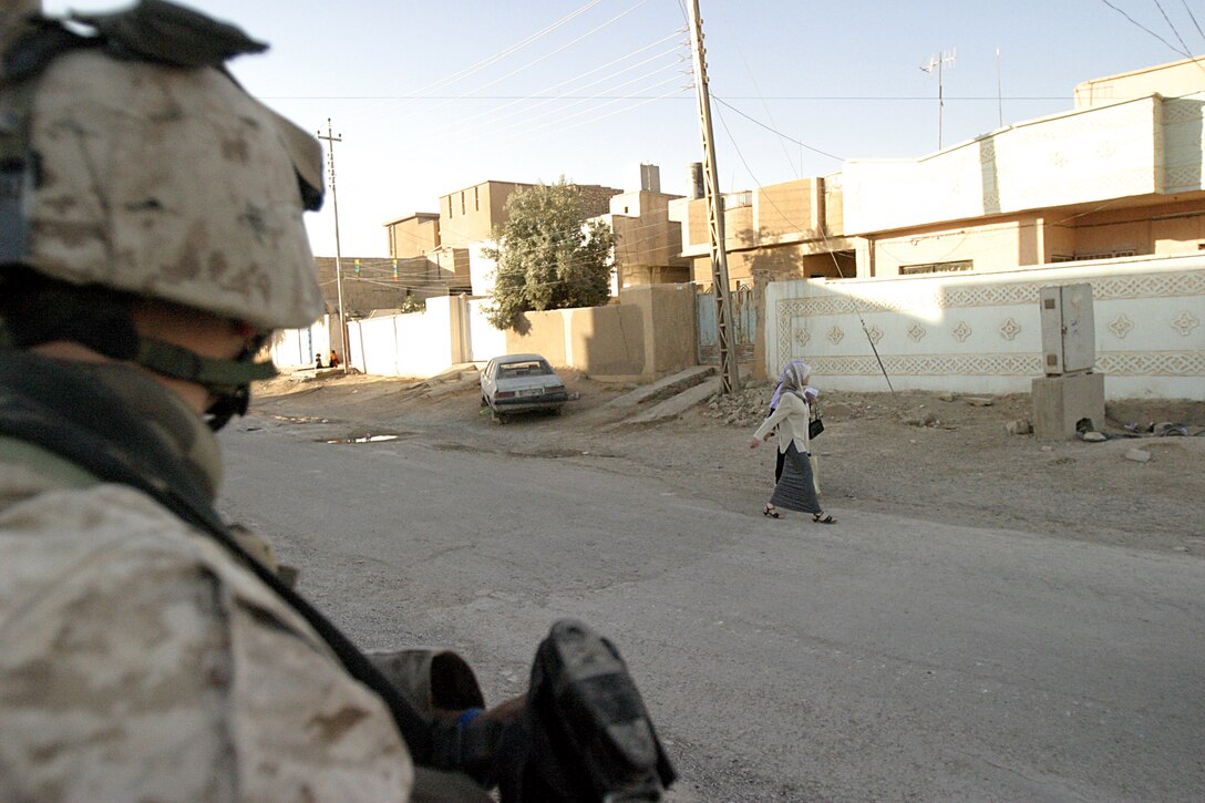 Hit, Al Anbar, Iraq (June 29, 2005)--A Marine with 1st platoon, Lima Co., 3/25 watches as Iraqi civilians carry on with with thier daily lives during Operation Sword. (Official USMC Photo by Corporal Ken Melton)
