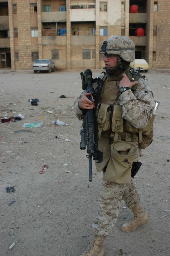 AR RAMADI Iraq (July 19, 2005) - Sergeant Aaron P. Selby, 3rd Squad leader, 1st Platoon, Company C, 1st Battalion, 5th Marine Regiment, uses his radio to communicate with his fellow Marines during a mission in the city here July 19. The 26-year-old from Ft. Thomas, Ky., is a husband a father of two. Nicole, his wife of six years, their three-year-old daughter Amara and two-year-old son Memphis are at home in Oceanside, Calif., while he fights the war on terror halfway around the world. The Selbys will be reunited in October after seven months of separation when 1st Battalion, 5th Marines return to Camp Pendleton, Calif. Photo by: Cpl. Tom Sloan