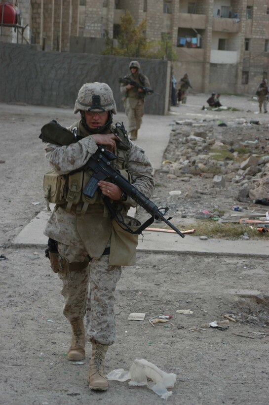 AR RAMADI Iraq (July 19, 2005) - Sergeant Aaron P. Selby, 3rd Squad leader, 1st Platoon, Company C, 1st Battalion, 5th Marine Regiment, uses his radio to communicate with his fellow Marines during a mission in the city here July 19. The 26-year-old from Ft. Thomas, Ky., is a husband a father of two. Nicole, his wife of six years, their three-year-old daughter Amara and two-year-old son Memphis are at home in Oceanside, Calif., while he fights the war on terror halfway around the world. The Selbys will be reunited in October after seven months of separation when 1st Battalion, 5th Marines return to Camp Pendleton, Calif. Photo by: Cpl. Tom Sloan