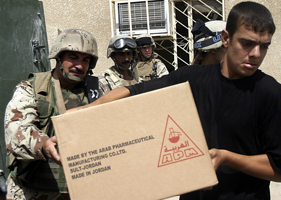 Hit, Al Anbar, Iraq -Commanding officer of Company 1, Col. Mahdi A. Mohammed, a 39-year-old Mosul native, soldiers with Iraq Security Force and Marines hand out medical supplies to local hospital. (Official USMC Photo by Corporal Ken Melton)