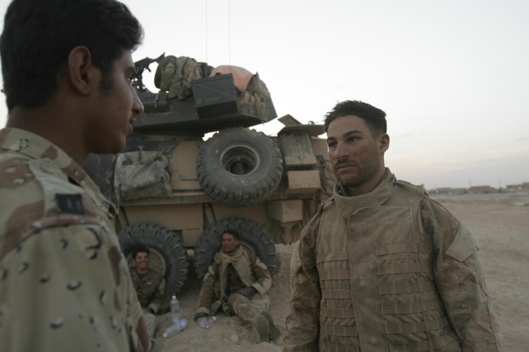 BARWANA, Iraq (October 14, 2005)- Kuwaiti born Cpl. Yousef A. Badou, a 22-year-old scout for 1st Light Armored Reconnaissance Battalion Jump Team uses his Arabic speaking skill to speak with an Iraqi soldier during  Operation River Gate. Operation River Gate is the effort  to conduct counter-insurgency operations with Iraqi Security Forces to isolate and neutralize anti-Iraqi forces, to support the continued development of Iraqi Security Forces, and to support Iraqi reconstruction and democratic elections in order to create a secure environment that enables Iraqi self-reliance and self-governance. (Official USMC photo by Cpl. Ken Melton)