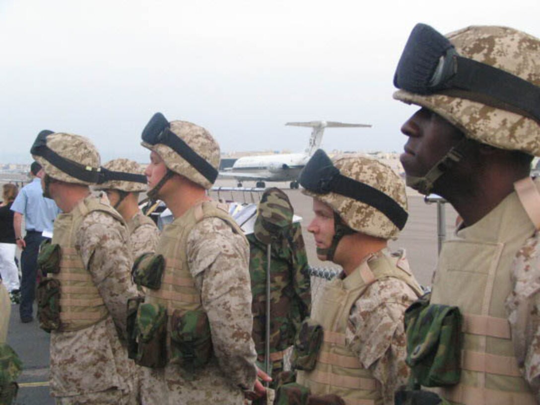 Sgt. Ralph Hammond, Prior Service Recruiter admininstrative clerk (right) waits with other Marines on the flight line before filming a scene depicting a unit deploying to Iraq.