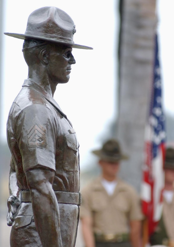 A bronze drill instructor, one of two figures that make up the depot's Drill Instructor Monument, stands during a ceremony at Shepherd Field Oct. 21.