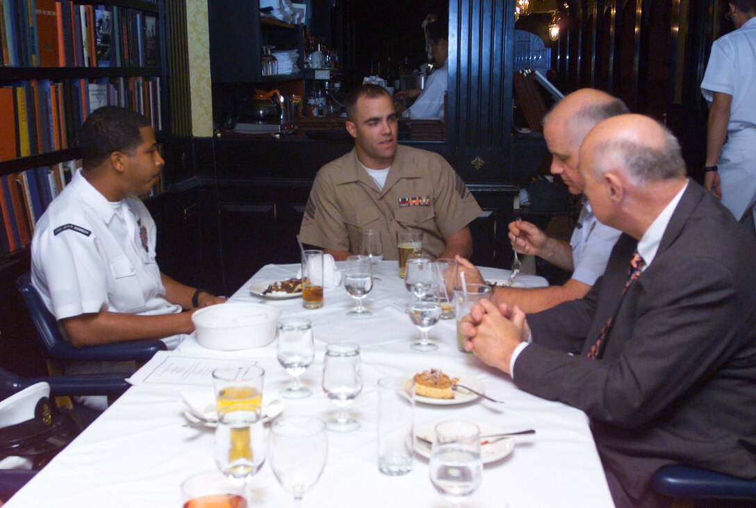 Sgt. James M. Pribyl shares war stories with fellow servicemembers of the year over dinner at Hurley's in New York. Pribyl, a logistics specialist with the 24th Marine Expeditionary Force, was the unit's Marine of the Year. The distinction has brought many unexpected honors to the New York native, including throwing out the first pitch at the opening game for the Mets; ringing the bell at the Stock Exchange; and the dinner at Hurley's. The Dinner, which was attended by the servicemembers of the year from Marine, Navy and Coast Guard units, was hosted by Ralph W. Slane, a former sailor turned pilot who's distinctions include being the fist pilot to fly commercially from New York to Tokyo. He has hosted a dinner for servicemembers of the year for the past 18 yeas during New York's annual Fleet Week celebration. (photo by Staff Sgt. David L. Crockett)