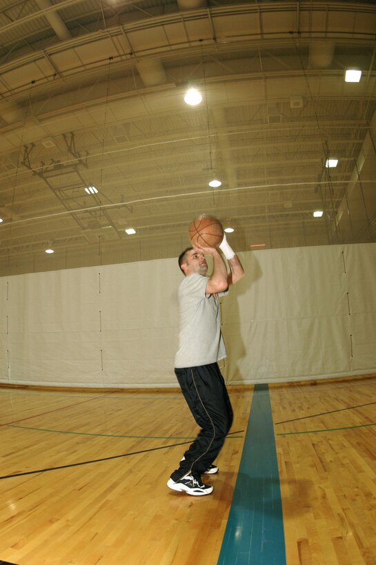 ELLSWORTH AIR FORCE BASE, S.D. -- Senior Airman Brian Fenton shoots hoops on a basketball court here.  He has had to learn to compete with limited use of his left arm since an automobile accident in November, 2003.  Airman Fenton is an air traffic control apprentice assigned to the 28th Operations Support Squadron here.  (Courtesy photo)