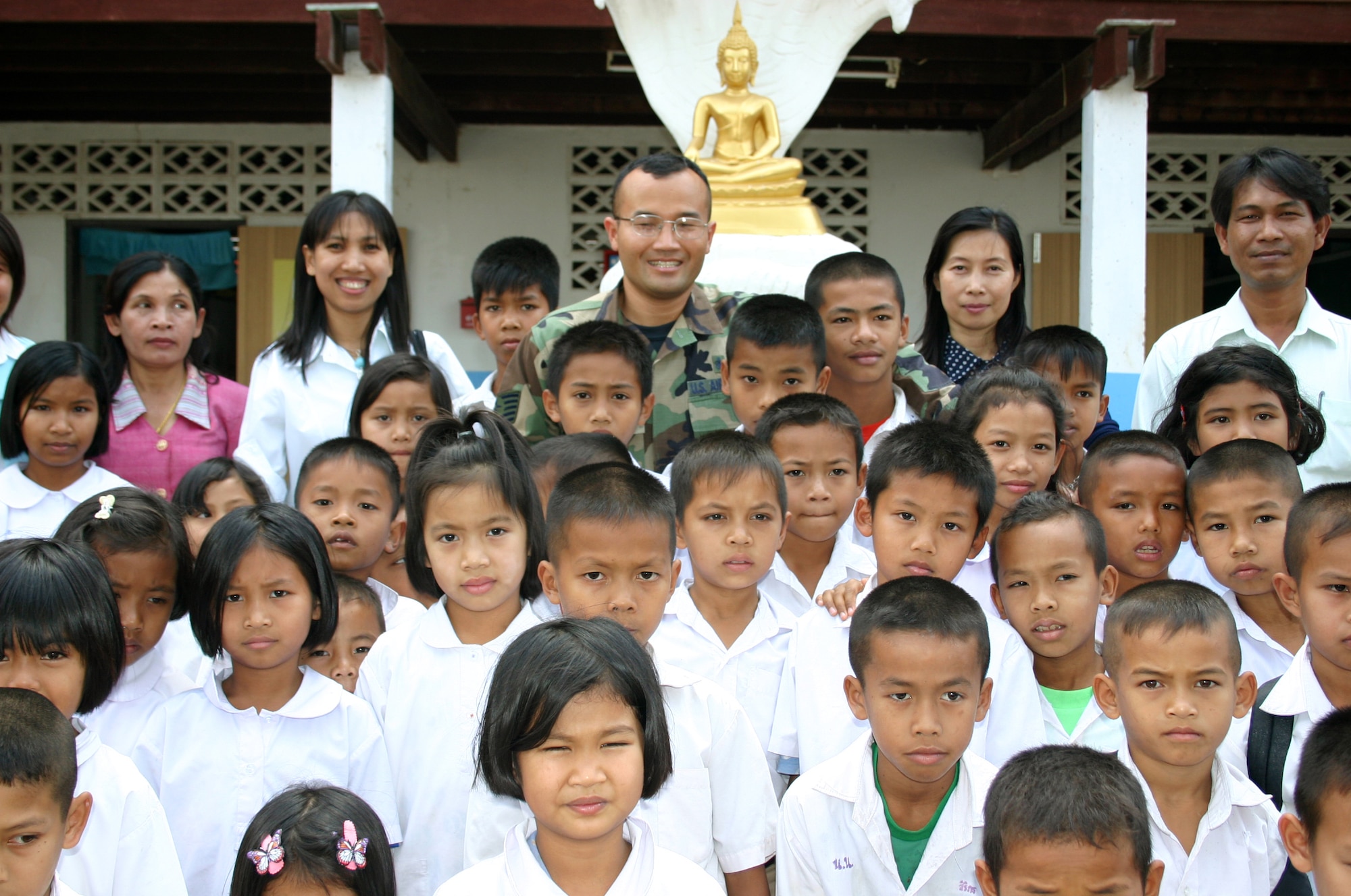 KORAT, Thailand (AFPN) -- Tech. Sgt. Siamrad Maher poses with schoolchildren at a school here as a part of a humanitarian outreach program during the Cope Tiger 2005 exercise Jan. 27.  Military medical teams from the U.S. Air Force, U.S. Navy, Thailand and Singapore are giving ocular and dental care to Thais citizens.  He is here from the 18th Medical Group at Kadena Air Base, Japan.  (U.S. Air Force photo by 2nd. Lt. Ben Sakrisson)