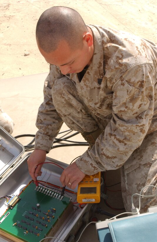 Sgt. Mauricio Cano, 23, from Naples, Fla., Marine Air Control Squadron 1, 2nd Marine Aircraft Wing, test the voltage on naviagational equipment used to signal pilots.  The equipment provides pilots with distance to Al Qaim, Iraq, coordinates to Al Qaim to aid pilots in the direction to fly.