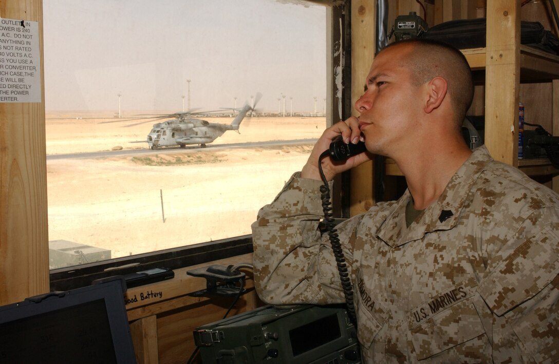 Sgt. Jacob M. Zamora, 23, Corpus Christi, Texas, air traffic controller, communicates with a CH-53 Sea Knight helicopter pilot before lifting off.  This Marine is assigned to Marine Air Control Squadron 1, 2nd Marine Aircraft Wing, Al Qaim, Iraq.