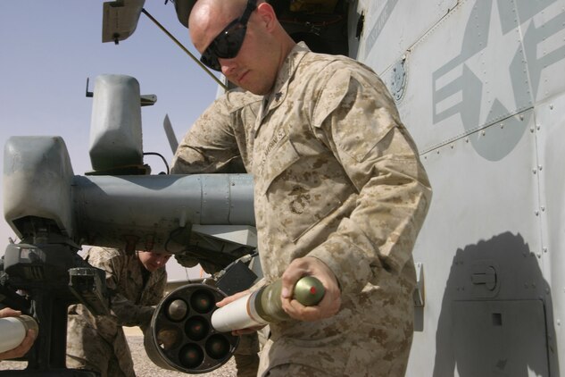 Corporal Garrett Pellerzi, ordnance technician, Marine Light/Attack Helicopter Squadron 269, loads a rocket aboard Forward Operating Base Al Qaim, March 29.