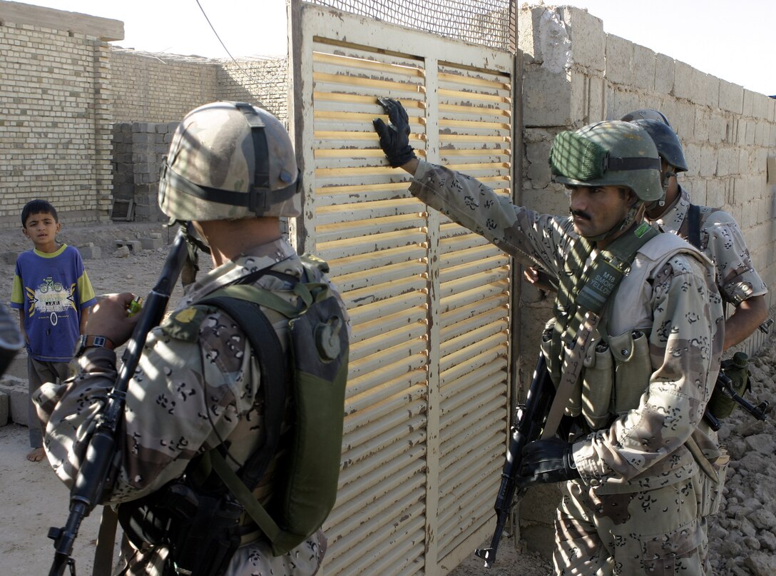 SAQLAWIYAH, Iraq - Iraqi soldiers knock on a residency's door in a village outside Saqlawiyah codenamed 'Shadyville' and proceed to enter it to search for weapons and explosives.  Iraqi Security Forces assisted Company A, 1st Battalion, 6th Marine Regiment personnel during 'Operation Shadyville,' a mission that netted several suspected insurgent supporters, two improvised explosive devices, and 50 AK-47 assault rifles.
