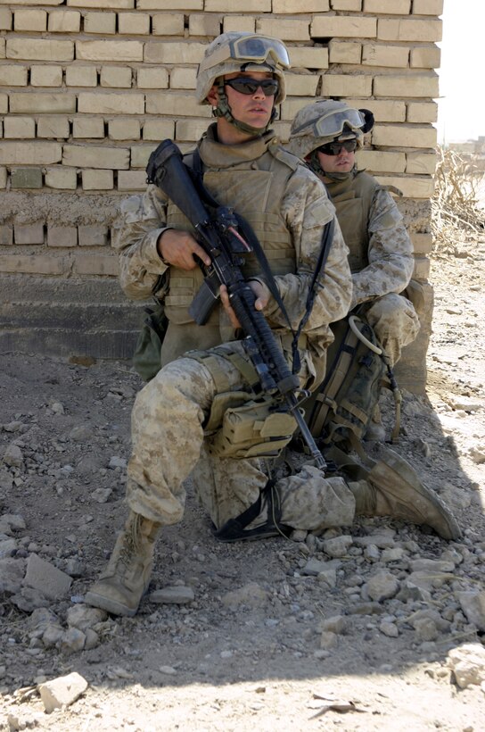 SAQLAWIYAH, Iraq - Lance Cpl. Howard Aycock, a machine gunner with 2nd Platoon, Company A, 1st Battalion, 6th Marine Regiment, and a Navy corpsman provide security in a village outside Saqlawiyah codenamed 'Shadyville' June 29.  Aycock, a 26-year-old Sarasota, Fla. native, and his unit assisted the Iraqi Security Forces during 'Operation Shadyville,' a mission that netted several suspected insurgent supporters, two improvised explosive devices, and 50 AK-47 assault rifles.