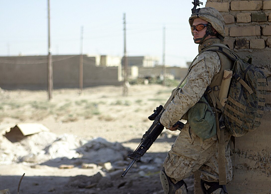 SAQLAWIYAH, Iraq - A Marine with Company A, 1st Battalion, 6th Marine Regiment provides security at a street corner in a village outside Saqlawiyah codenamed 'Shadyville' June 29.  Company A personnel assisted the Iraqi Security Forces during 'Operation Shadyville,' a mission that netted several suspected insurgent supporters, two improvised explosive devices, and 50 AK-47 assault rifles.