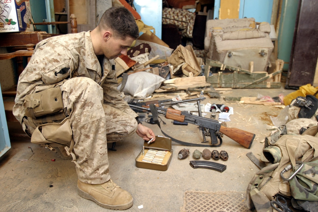 Hit, Al Anbar, Iraq (June 29, 2005)--Billings, Mont.,native, Sgt. Phillip R. Jolly, a squad leader with 1st platoon, Lima Co., 3/25, inspects some of the weaponry Marines in his squad found. (Official USMC Photo by Corporal Ken Melton)
