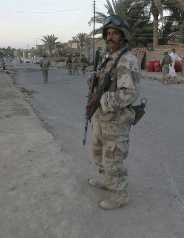 HIT, Iraq-(June 29, 2005) An Iraqi Security Force soldier patrols with Marines of Headquarters Company, 3rd Battalion, 25th Marine Regiment.  They swept the streets here in search of terrorist activity.  U.S. Marine Corps photo by Lance Cpl. Kevin N. McCall (RELEASED)