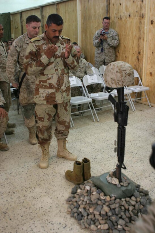 HADITHA, Iraq (Nov. 29, 2005)  - An Iraqi Army officer pay respects during a memorial service for Lance Cpl. Miguel Terrazas' here Nov. 29. The El Paso, Texas native served bravely as a rifleman with Kilo Company, 3rd Battalion, 1st Marine Regiment where he made many friends and will be sorely missed by all un his unit. (Official Marine Corps photo by Cpl. Adam C. Schnell)