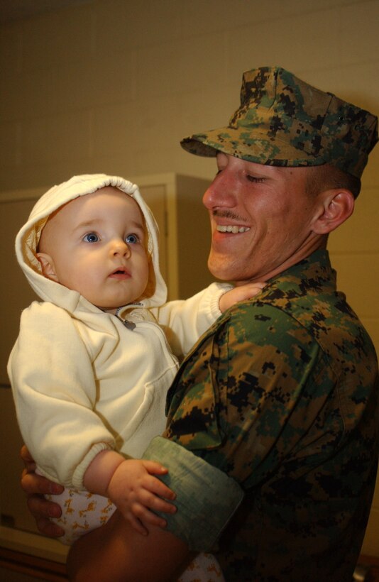 In the last few hours before the sun lifted the darkness, Sgt. Chad M. Lacasse, section chief, India Battery, 3rd Battalion, 11th Marine Regiment, holds his infant daughter Nora just before India?s deployment to Okinawa.  This will be Lacasse?s fourth deployment with India.  He was deployed to Iraq when Nora was born, and will miss her first birthday, as well as her first steps.
