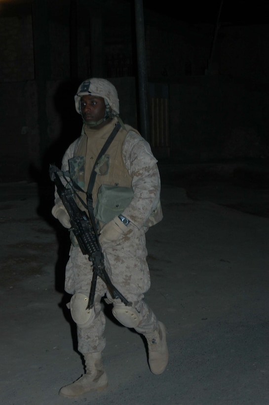 AR RAMADI, Iraq (March 29, 2005) - Twenty-one-year-old Lance Cpl. Daniel D. Edwards, squad automatic gunner, 3rd Squad, 2nd Platoon, Company C, 1st Battalion, 5th Marine Regiment, from Jackson, Mich., walks down a dark street with his weapon in hand. Marines with 2nd Platoon, Company C, 1st Battalion, 5th Marines, conducted a late-night combat patrol in a portion of the city here where groups of Iraqis, possibly insurgents, have been seen gathering after curfew hours, which are from 10 p.m. and 6 a.m. The Marines discovered a group of Iraqi teens playing soccer beneath a streetlight and several adults gathered in the street in front of their residences. The Marines finished the patrol without incident and returned to their base camp at Snake Pit. Photo by Cpl. Tom Sloan