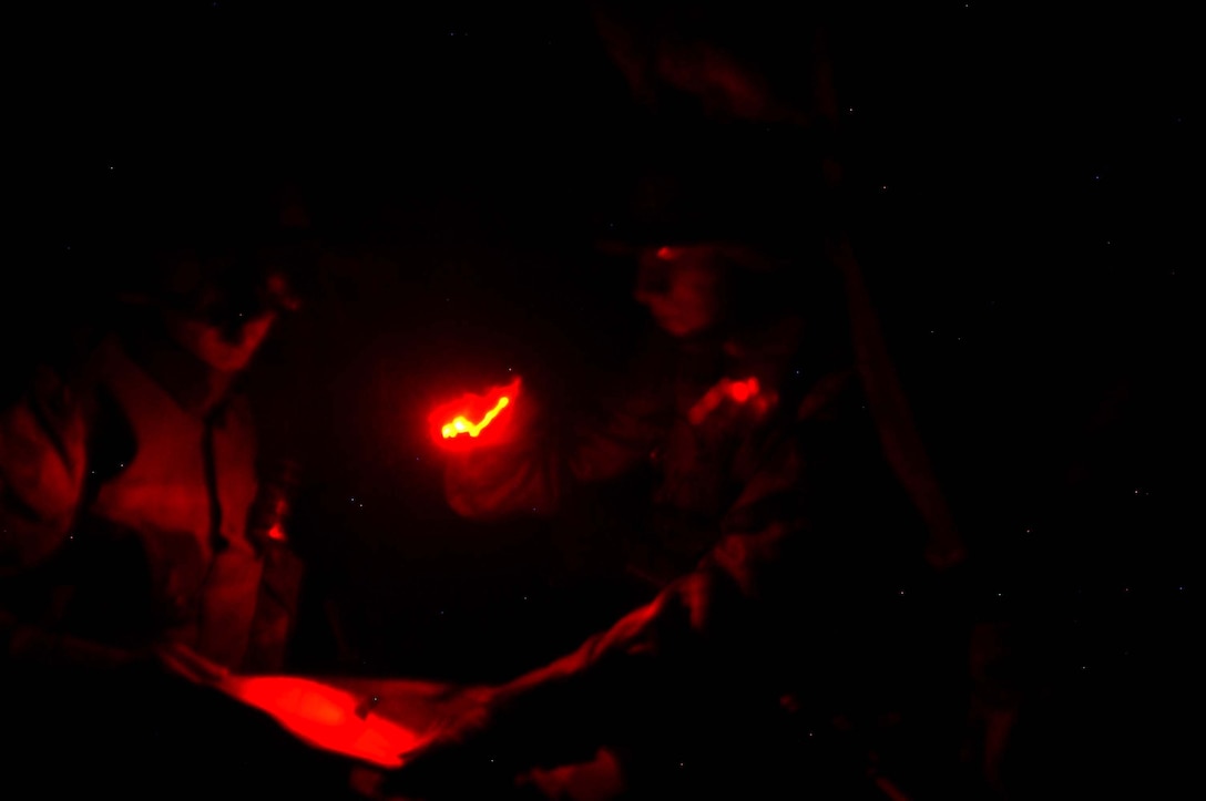 AR RAMADI, Iraq (March 29, 2005) - Twenty-one-year-old Cpl. James P. Kohler Jr., squad leader, 3rd Squad, 2nd Platoon, Company C, 1st Battalion, 5th Marine Regiment, from Grandterrace, Calif., checks his squad's location while on top of an abandoned building they're using as an over watch. He uses a red lens so not to give away his squad's location.  Marines with 2nd Platoon, Company C, 1st Battalion, 5th Marines, conducted a late-night combat patrol in a portion of the city here where groups of Iraqis, possibly insurgents, have been seen gathering after curfew hours, which are from 10 p.m. and 6 a.m. The Marines discovered a group of Iraqi teens playing soccer beneath a streetlight and several adults gathered in the street in front of their residences. The Marines finished the patrol without incident and returned to their base camp at Snake Pit. Photo by Cpl. Tom Sloan