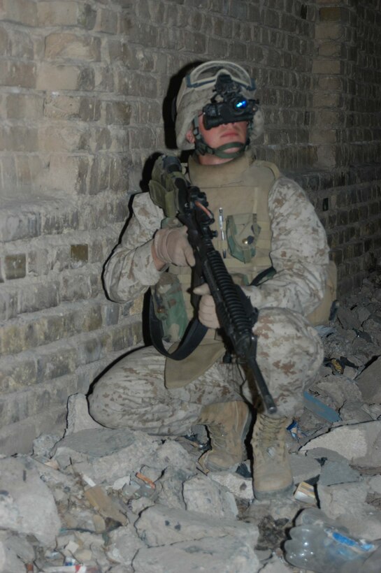AR RAMADI, Iraq (March 29, 2005) - A Marine with Quick Reaction Force, 4th Platoon, Company C, 1st Battalion, 5th Marine Regiment, looks through his night vision goggles for insurgents and other threats against his fellow Marine while posting security on a dark, city street. Marines with 2nd Platoon, Company C, 1st Battalion, 5th Marines, conducted a late-night combat patrol in a portion of the city here where groups of Iraqis, possibly insurgents, have been seen gathering after curfew hours, which are from 10 p.m. and 6 a.m. The Marines discovered a group of Iraqi teens playing soccer beneath a streetlight and several adults gathered in the street in front of their residences. The Marines finished the patrol without incident and returned to their base camp at Snake Pit. Photo by Cpl. Tom Sloan