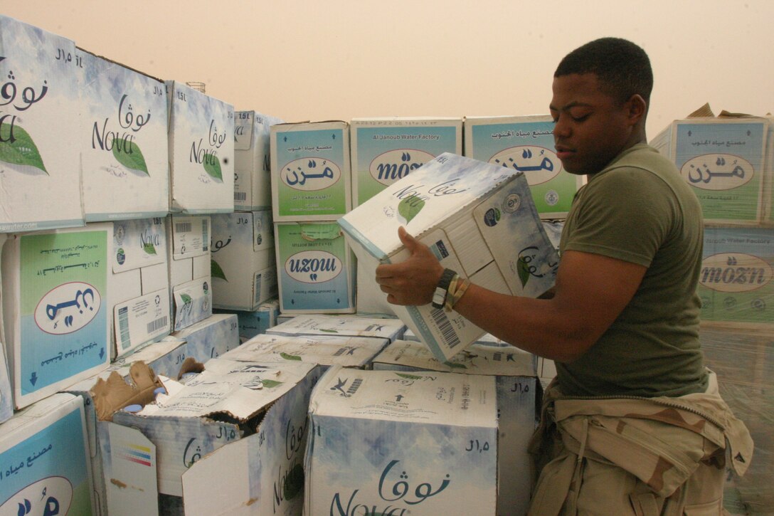 CAMP AL QA'IM, Iraq (April 14, 2005)- Lance Cpl. Robert E. James, III, 19, a warehouse clerk with 3rd Battalion, 2nd Marine Regiment, Regimental Combat Team-2 stacks the battalion's water supply here.  James, a Roanoke, Va., native joined the Marines after his father presented the option to him. The 2003 William Fleming High School gradute describes his high school years as his troubled times and thanks the Corps for his turn around. Official U.S. Marine Corps photo by Lance Cpl. Lucian Friel (RELEASED)