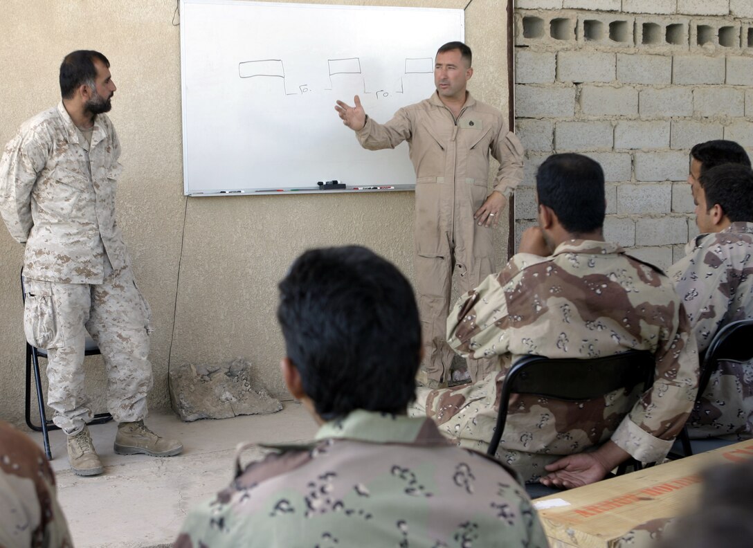 CAMP BAHARIA, Iraq - Staff Sgt. George Ferguson, 1st Battalion, 6th Marine Regiment's motor transport maintenance chief, lectures a class of Iraqi soldiers here June 30.  1st Battalion, 6th Marine Regiment motor transport personnel instructed these soldiers on topics such as how to organize a logistics convoy and perform basic preventive maintenance on their vehicles, as part of the battalion's ongoing effort to train the Iraqi Security Forces.