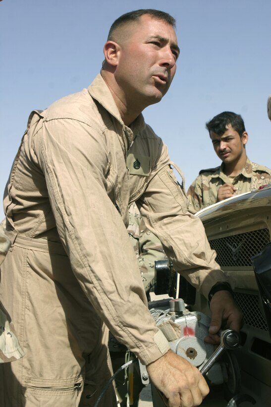 CAMP BAHARIA, Iraq - Staff Sgt. George Ferguson, 1st Battalion, 6th Marine Regiment's motor transport maintenance chief, shows Iraqi soldiers how to install a tow winch on their vehicle during a class here June 30.  1st Battalion, 6th Marine Regiment motor transport personnel instructed these soldiers on topics such as how to organize a logistics convoy and perform basic preventive maintenance on their vehicles, as part of the battalion's ongoing effort to train the Iraqi Security Forces.