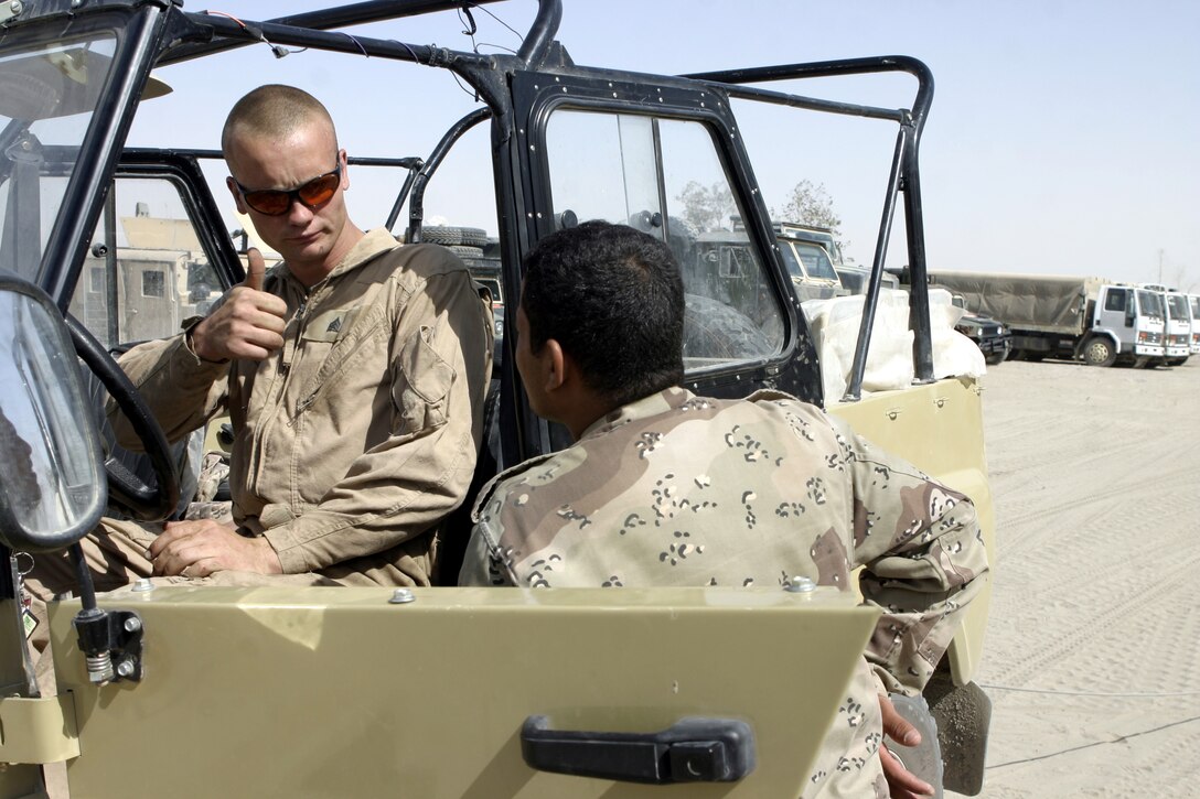 CAMP BAHARIA, Iraq -Sgt. Bob Stoddard, 1st Battalion, 6th Marine Regiment's motor transport maintenance shop chief, gives an Iraqi soldier a "thumbs-up" sign while speaking with him during preventive maintenance class here June 30.  The 25-year-old Allegan, Mich. native's unit instructed these soldiers on topics such as how to organize a logistics convoy and perform basic preventive maintenance on their vehicles, as part of the battalion's ongoing effort to train the Iraqi Security Forces.