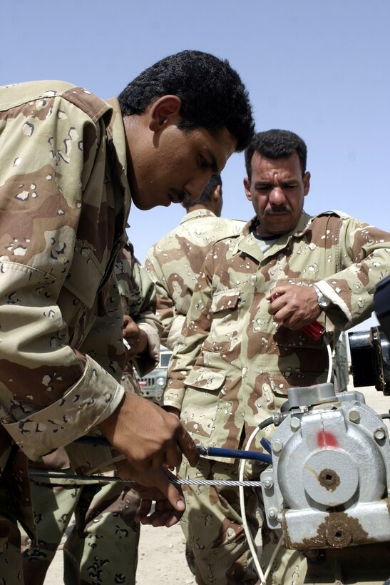 CAMP BAHARIA, Iraq - An Iraqi soldier adjusts a tow winch aboard his vehicle during a vehicular preventive maintenance class here June 30.  1st Battalion, 6th Marine Regiment motor transport personnel instructed these soldiers on topics such as how to organize a logistics convoy and perform basic preventive maintenance on their vehicles, as part of the battalion's ongoing effort to train the Iraqi Security Forces.
