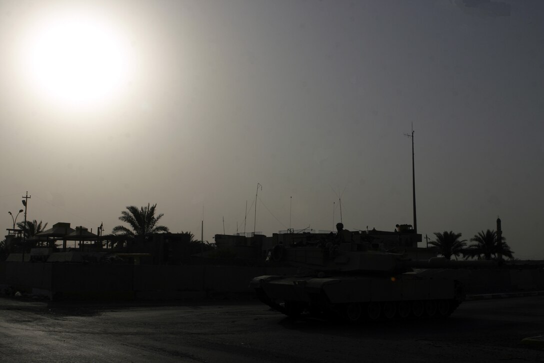 FALLUJAH, Iraq - As the sun begins to set, an M1A1 Abrams tank provides area security alongside a street intersection here during a recent operation.  M1A1 Abrams tank crewmen from 2nd Tank Battalion, 2nd Marine Division assist ground infantry units provide security and stability throughout western Iraq's Al Anbar province.