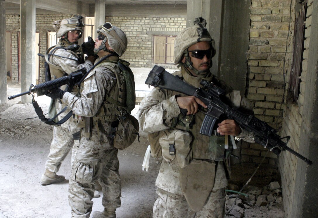 FALLUJAH, Iraq - Lance Cpl. Henry Andelo de Armas, an infantryman with 1st Platoon, Company C, 1st Battalion, 6th Marine Regiment, right, helps fellow Marines search through a half-ruined building here July 24.  Company C is currently working alongside Iraqi Security Forces to conduct security and stability operations throughout Fallujah.