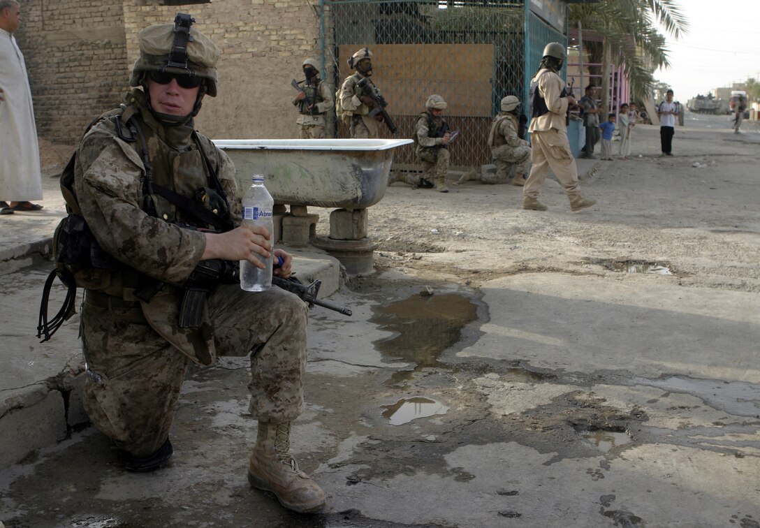 FALLUJAH, Iraq - Lance Cpl. William Sundbeck, an infantryman with 1st Platoon, Company C, 1st Battalion, 6th Marine Regiment, stops for a drink of water after patrolling the city streets July 24.  Company C is currently working alongside Iraqi Security Forces to conduct security and stability operations throughout Fallujah.