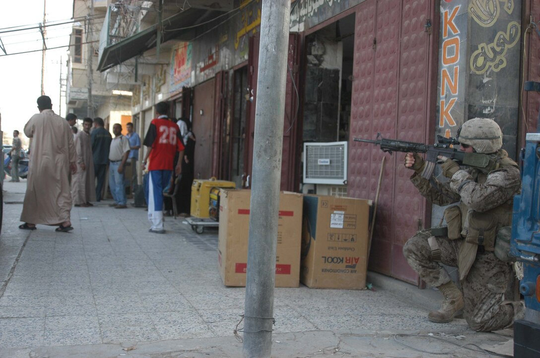 AR RAMADI Iraq (July 25, 2005) - Lance Cpl. Joel M. Myers, a rifleman with 1st Squad, 2nd Platoon, Company A, 1st Battalion, 5th Marine Regiment, provides security from a street corner during a mission in the city here July 25. Twenty-year-old Myers from Memphis, Mo., and fellow Marines with the Camp Pendleton, Calif., -based infantry battalion conducted a battalion-wide operation in the city's marketplace, where they searched vehicles and personnel for weapons and improvised explosive making material. Photo by: Cpl. Tom Sloan