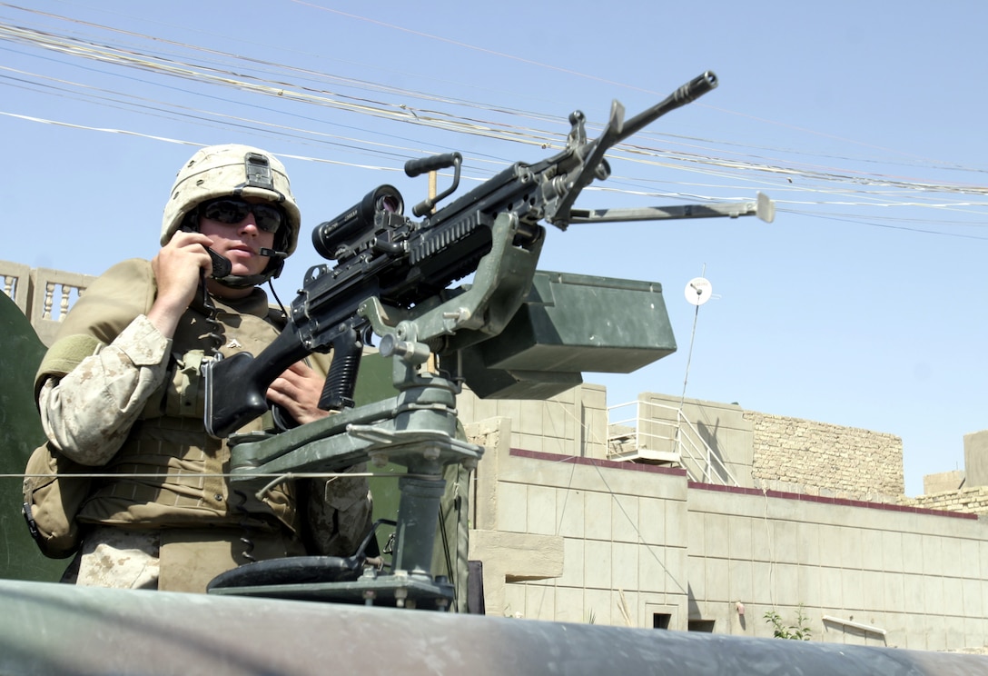 FALLUJAH, Iraq - Lance Cpl. Tim "Chip" Montgomery, a vehicle gunner with 1st Combined Anti-Armor Team, Weapons Company, 1st Battalion, 6th Marine Regiment, monitors radio traffic while scanning the city streets for threats Aug. 30.  The 19-year-old Williamsport, Penn. native and other Marines from his battalion's four CAAT platoons routinely patrol the city's streets and alleyways aboard their armored trucks and on foot to search for insurgent activity and improvised explosive devices.
