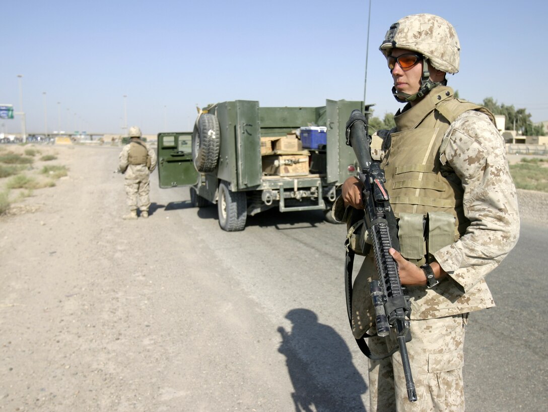 FALLUJAH, Iraq - A Marine with 1st Combined Anti-Armor Team, Weapons Company, 1st Battalion, 6th Marine Regiment provides security along a military avenue leading into Fallujah Aug. 30.  Marines from the battalion's four CAAT platoons routinely patrol the city's streets and alleyways aboard their armored trucks and on foot to search for insurgent activity and improvised explosive devices.