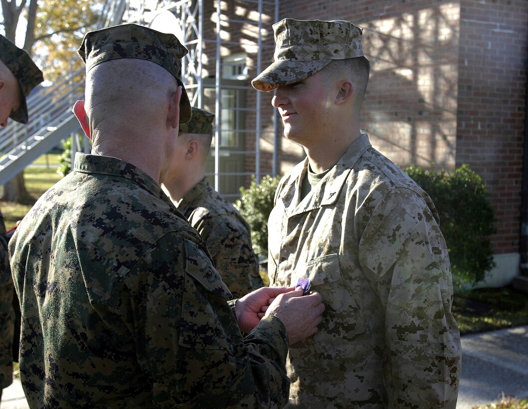 MARINE CORPS BASE CAMP LEJEUNE, N.C. - Lance Cpl. Ryan Cahill, an infantryman with 2nd Battalion, 2nd Marine Regiment, is presented his Purple Heart Medal here Nov. 30.  The 19-year-old Baton Rouge, La. native suffered shrapnel and other wounds in September after an improvised explosive device detonated near the vehicle he had been driving, causing it to tumble into a nearby canal.  Cahill and his teammates had been conducting an IED sweep in Karmah, a city outside Fallujah.