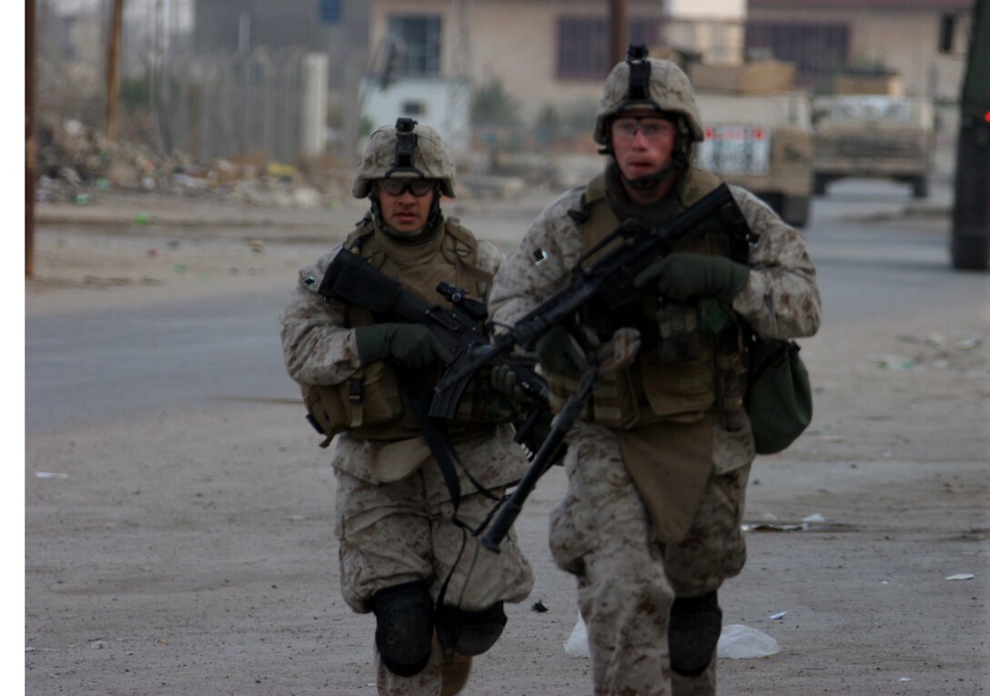AR RAMADI, Iraq ? Two Marines with Combined Anti-Armor Team White, 3rd Battalion, 7th Marine Regiment, run to get into position during Operation Block Party 6 Nov. 30.