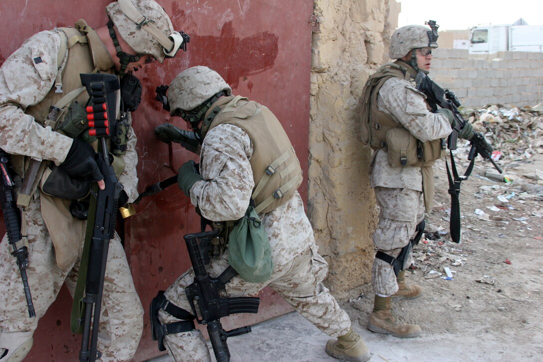AR RAMADI, Iraq (November 30, 2005) - Three Marines, all infantrymen with Combined Anti-Armor Team White, 3rd Battalion, 7th Marine Regiment, work on a lock in order to clear a building during Taskforce Block Party Six Nov. 30. Photo by Cpl. Shane Suzuki