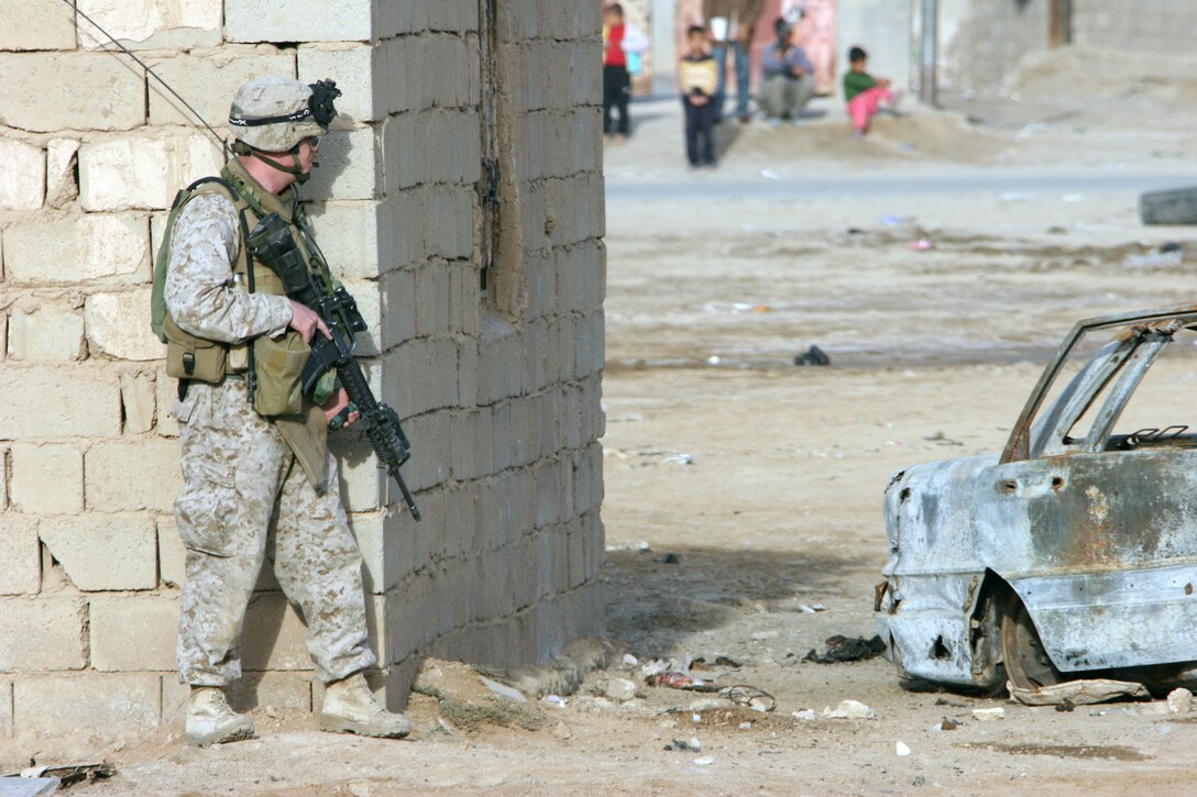 AR RAMADI, Iraq (November 30, 2005) - Captain Rory Quinn, commanding officer of Company L, 3rd Battalion, 7th Marine Regiment, takes cover near an abandoned building during Taskforce Block Party Six Nov. 30. Photo by Cpl. Shane Suzuki